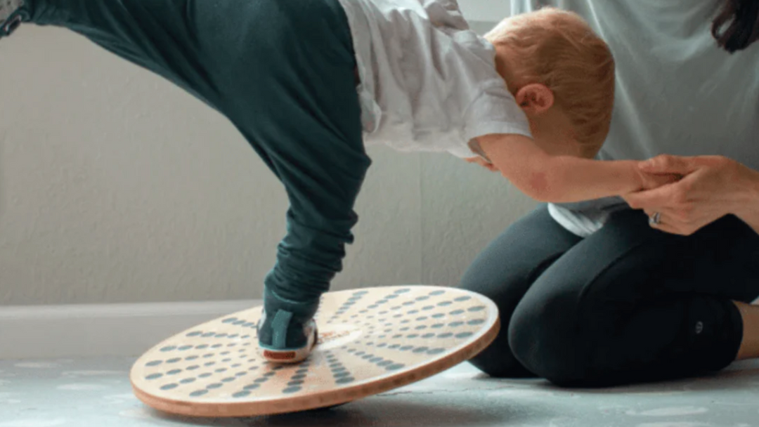 A woman and a child playing on a wooden board.