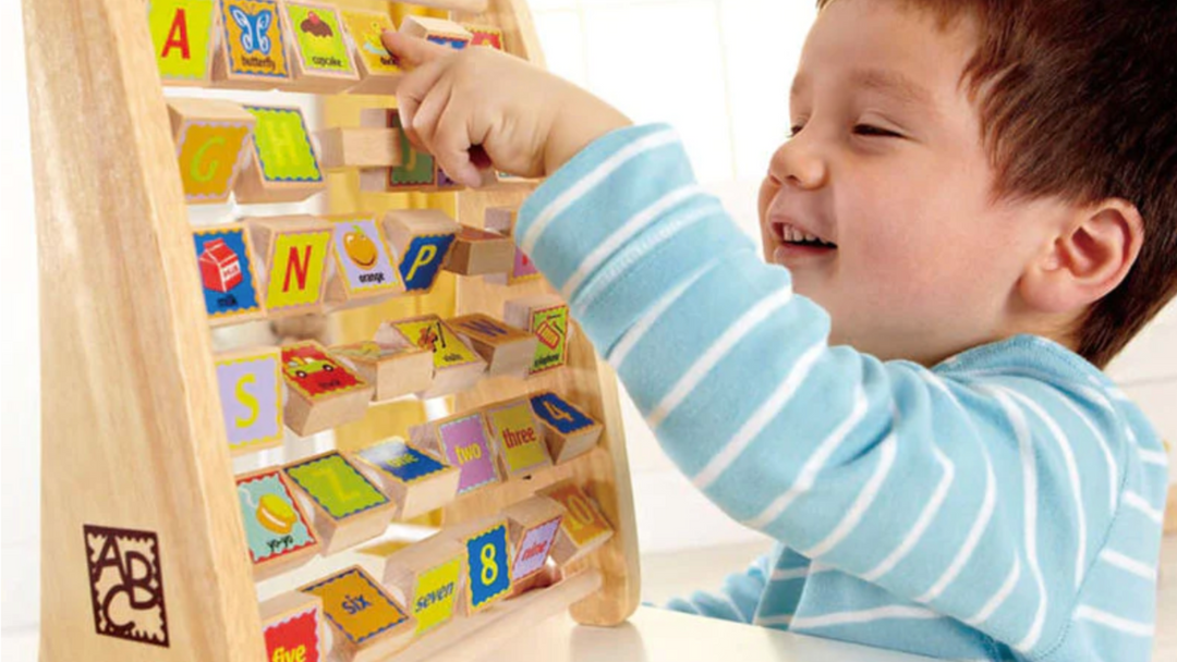 A young boy is playing with a wooden toy.