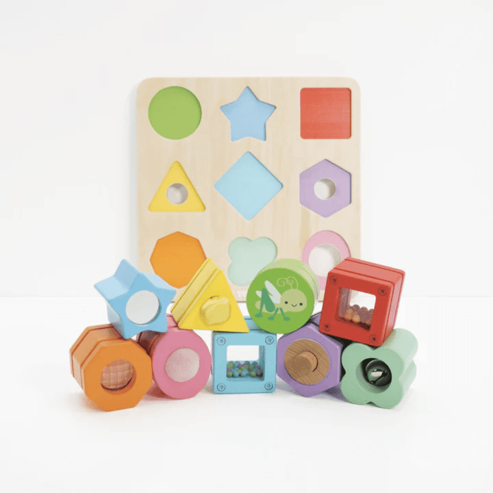 The Le Toy Van Petilou Sensory Shapes - LUCKY LAST features vibrantly colored wooden pieces that fit snugly into a matching board adorned with circles, stars, and squares, promoting sensory shape recognition and enhancing fine motor skills.