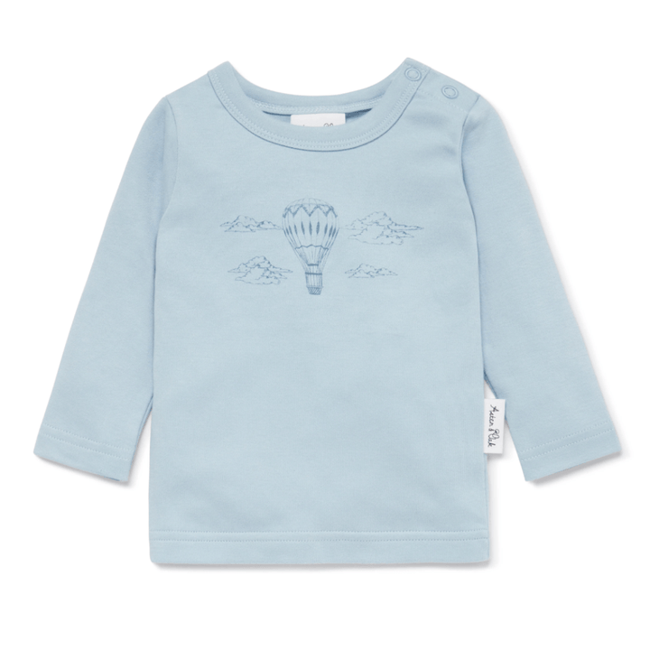 Introducing the Aster & Oak Organic Air Balloon Long-Sleeved Top, a light blue baby shirt adorned with embroidered hot air balloon and cloud designs. Crafted from soft organic cotton, this charming top features shoulder buttons on one side for easy dressing. Available in LUCKY LASTS sizes 4 years and 5 years only.