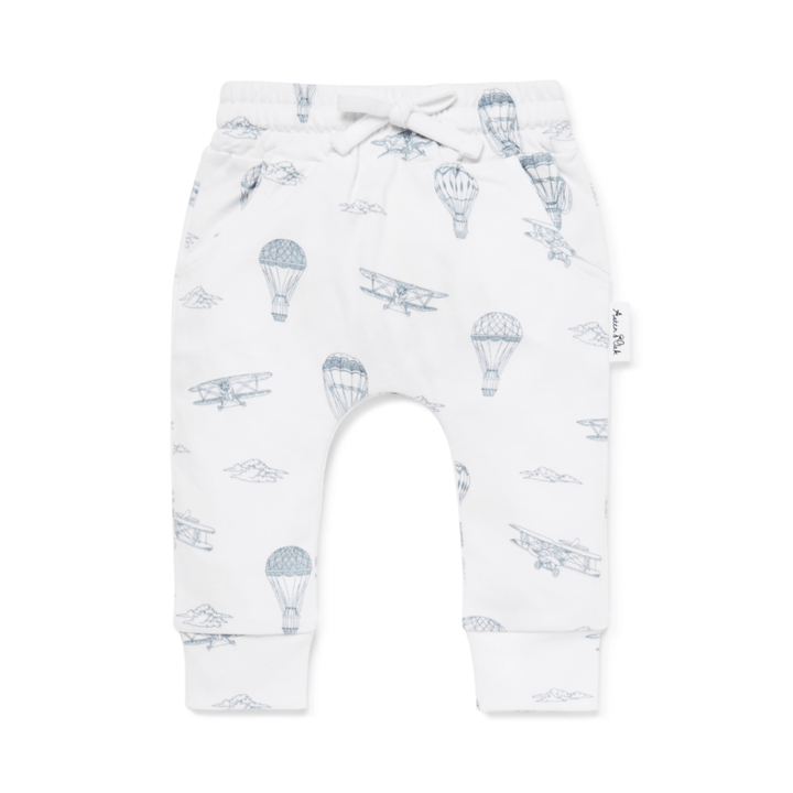 Discover the delightful Aster & Oak Organic Harem Pants, showcasing playful blue illustrations of hot air balloons and biplanes against a white backdrop. Made from GOTS-certified organic cotton, these pants feature a tied drawstring waist and cuffed ankles for both comfort and style. Available in sizes for 1-year-olds and 5-year-olds as part of their "LUCKY LASTS" collection.