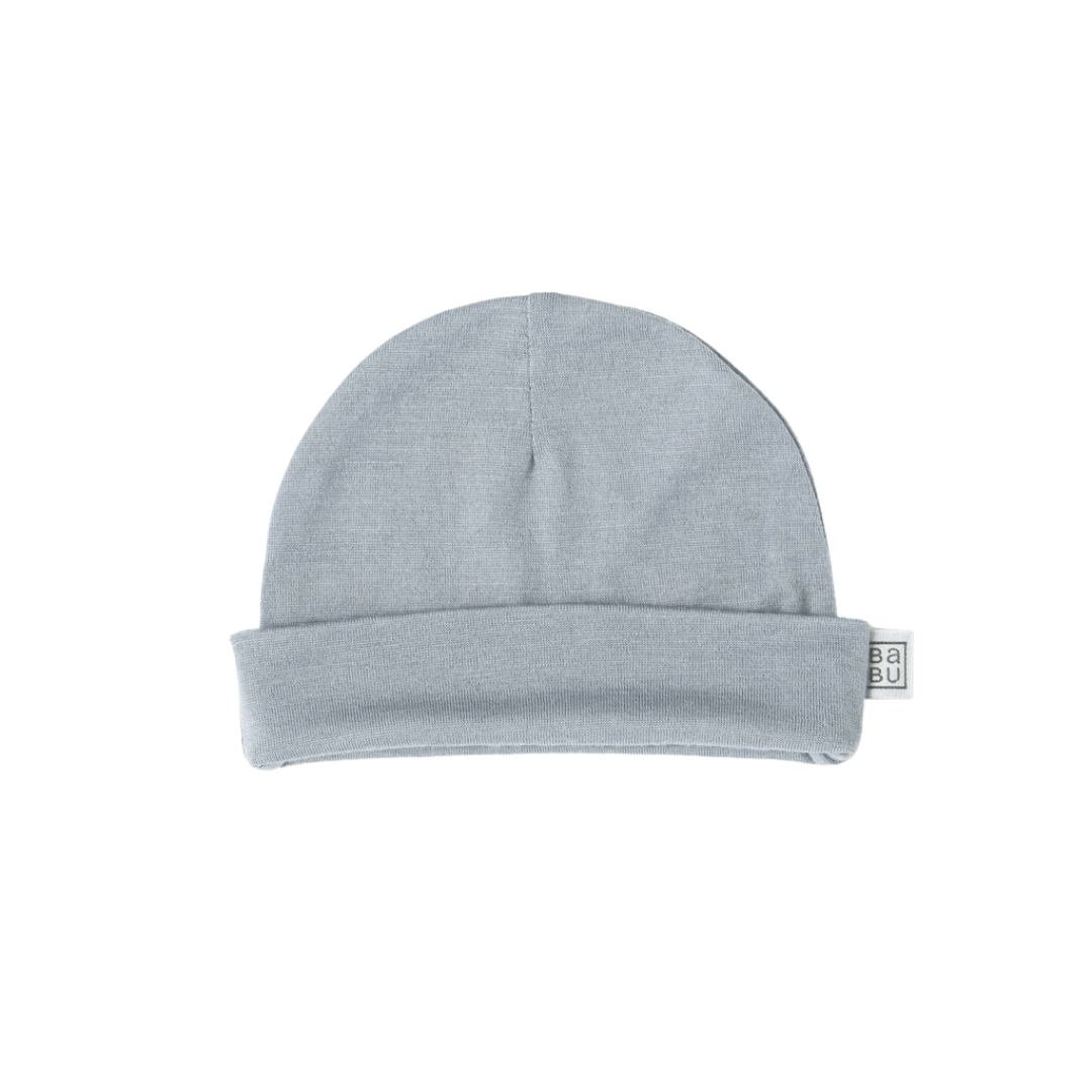 A simple, light gray beanie hat with a folded brim and a small tag on the side, this Babu Merino Baby Hat from Babu is a baby essential designed for a snug fit.