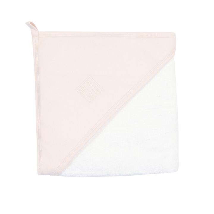 A Babu Printed Organic Hooded Baby Towel with a loop on one corner and a sewn-on diamond-shaped logo. The towel is light pink on one side and white on the other, made from 100% GOTS-certified organic cotton.