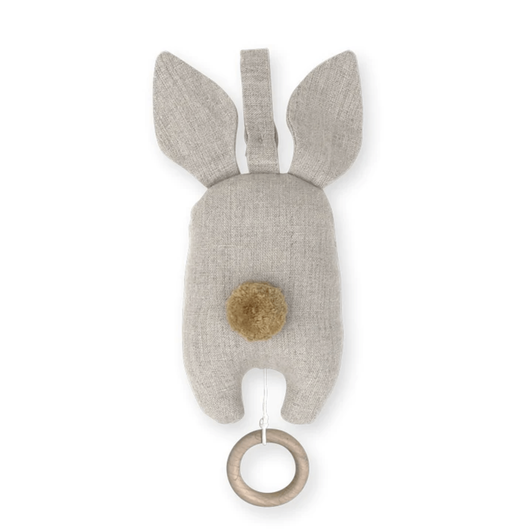 Saga Copenhagen's Organic Cotton Bunny Music Mobile is a plush, beige bunny-shaped toy with long ears, a pom-pom tail, and a wooden ring attached at the bottom. Crafted from GOTS certified materials, it makes for a perfect sustainable nursery accessory.