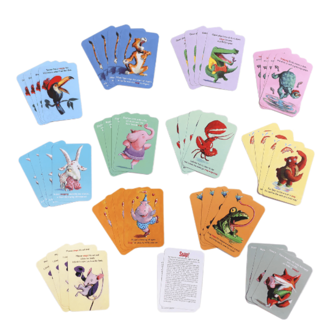 A variety of colorful, illustrated eeBoo Snap Playing Cards - LUCKY LAST are arranged in a circular pattern on a white surface. The central card appears to feature instructions for this fun card game.