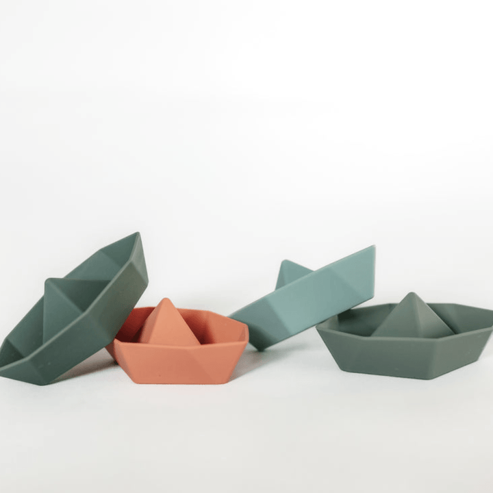 A set of four Classical Child silicone boat-shaped bowls on a white surface.