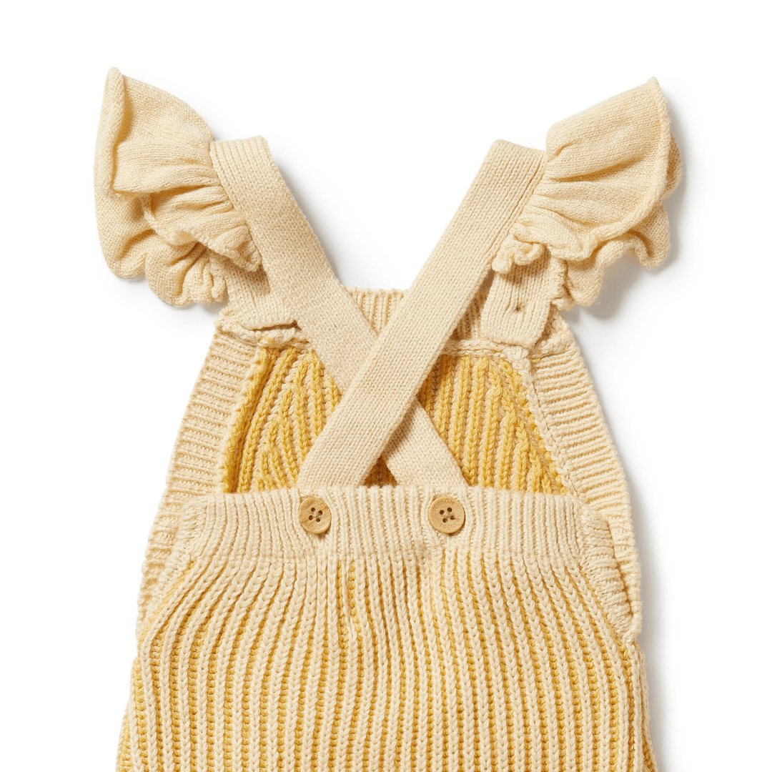 A Wilson & Frenchy Knitted Ruffle Overalls in Dijon, featuring crossed straps and ruffled sleeves, displayed on a white background.