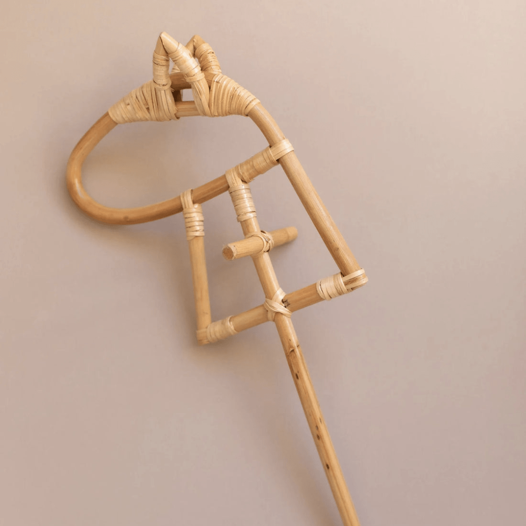 The Classical Child Rattan Hobby Horse - LUCKY LAST, shaped like a horse's head and perfect for imaginative play, sits against a plain beige background, emphasizing eco-responsibility.