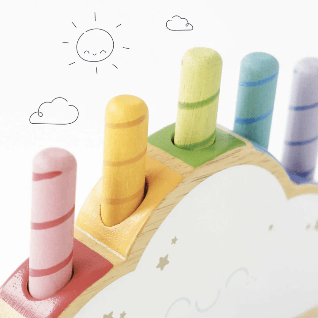 The Le Toy Van Rainbow Pop Cloud - LUCKY LAST is a delightful wooden toy featuring pastel-colored pegs set on a cloud-shaped base, adorned with cute doodles of the sun and clouds. It offers an eco-friendly gift option for toddlers, with rainbow pop-up rods that add an enchanting touch of whimsy to playtime.