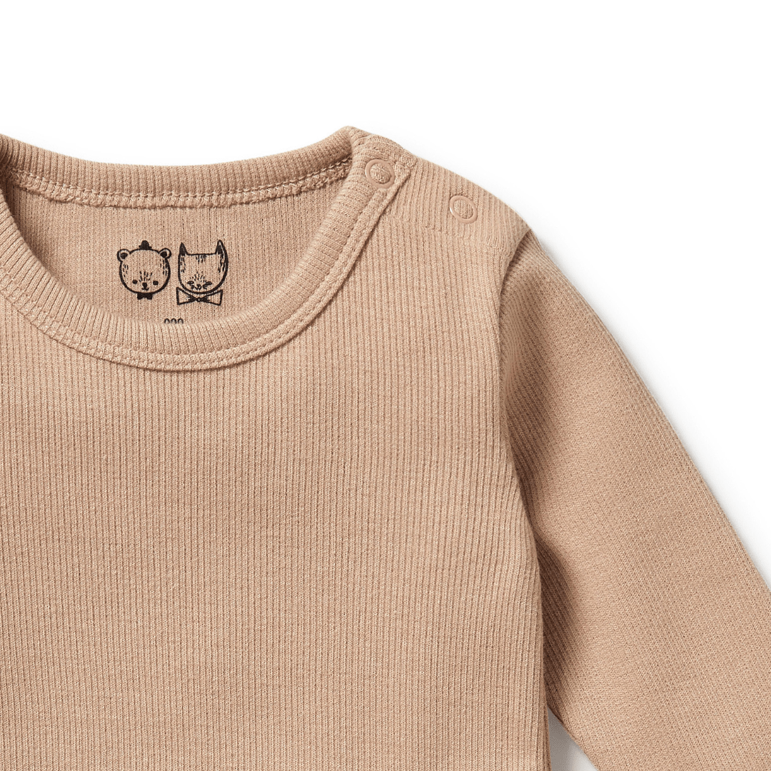 Close-up of the Wilson & Frenchy Organic Rib Long Sleeved Onesie - LUCKY LASTS - FAWN & PINK ONLY, made from GOTS-certified organic cotton. This beige baby onesie features ribbed fabric and two illustrated animal faces on the collar, with shoulder snap buttons for easy dressing.