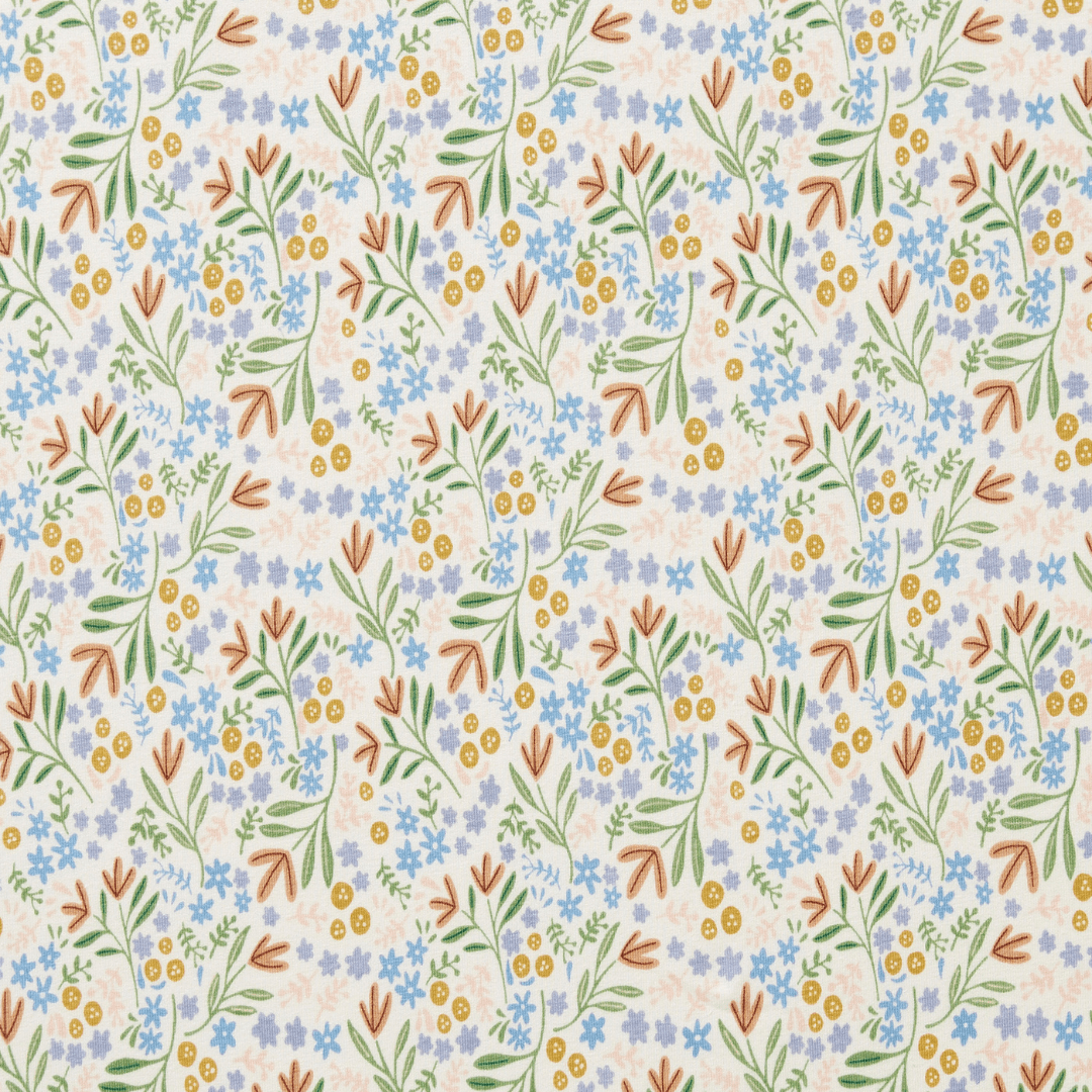 The Wilson & Frenchy Organic Cotton Cot Sheet - LUCKY LAST - TRIBAL WOODS ONLY features a delightful repeating pattern of botanical elements, including blue and yellow flowers, green leaves, and brown branches on a light background. This makes it an ideal baby shower gift for GOTS-certified nurseries.