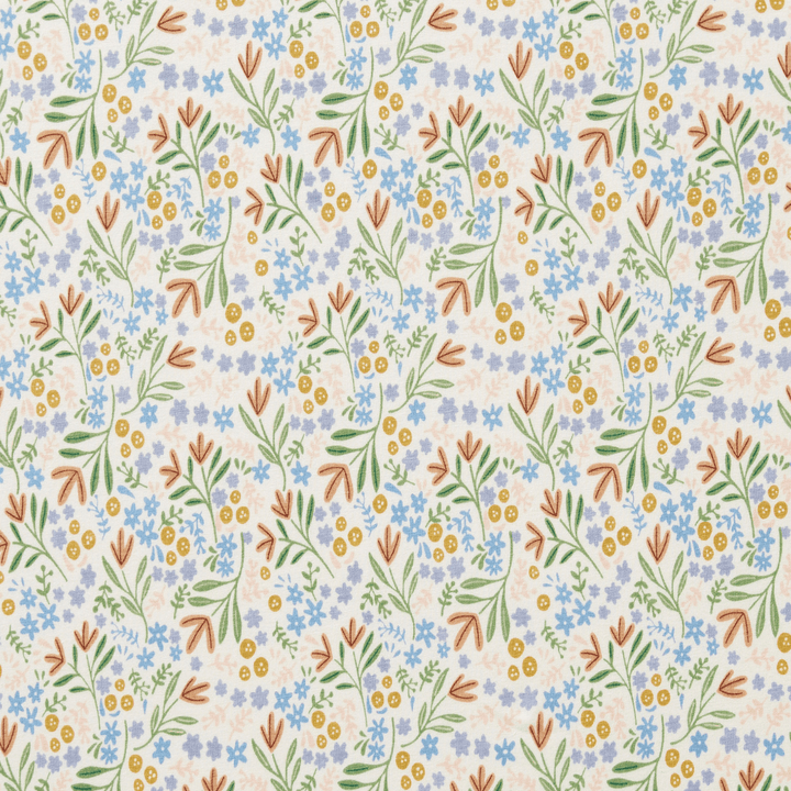 The Wilson & Frenchy Organic Cotton Cot Sheet - LUCKY LAST - TRIBAL WOODS ONLY features a delightful repeating pattern of botanical elements, including blue and yellow flowers, green leaves, and brown branches on a light background. This makes it an ideal baby shower gift for GOTS-certified nurseries.