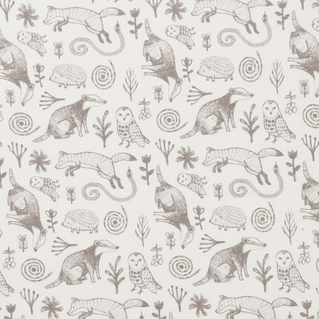 A seamless pattern featuring illustrations of various forest animals like foxes, owls, and hedgehogs, along with plants and flowers, all in a monochromatic brown color scheme on a white background. The Wilson & Frenchy Organic Cotton Cot Sheet - LUCKY LAST - TRIBAL WOODS ONLY is GOTS-certified and makes an ideal organic cotton cot sheet for a charming baby shower gift.