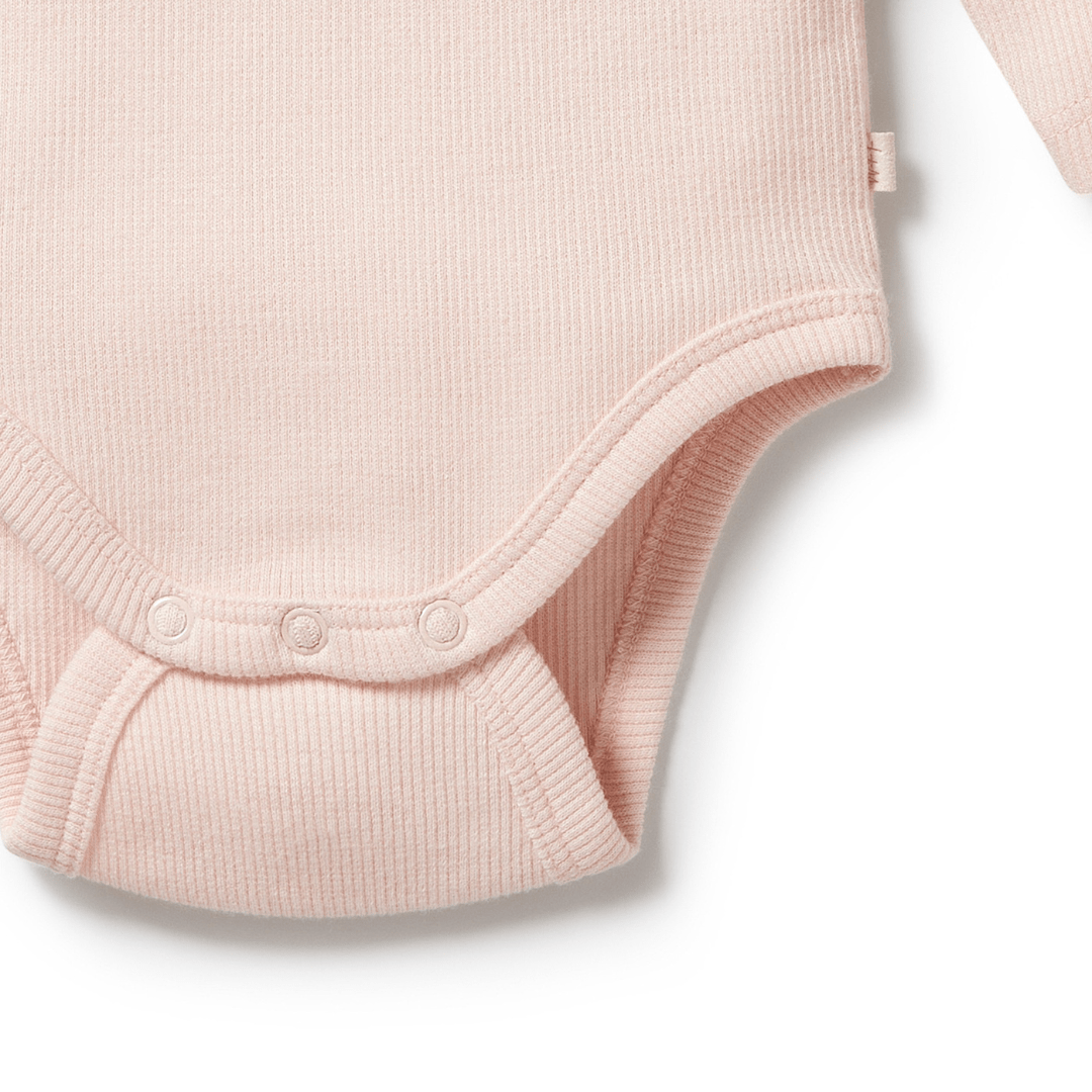 Explore the Wilson & Frenchy Organic Rib Long Sleeved Onesie - LUCKY LASTS, available exclusively in fawn and pink. Crafted from GOTS-certified organic cotton, this onesie features a charming ribbed texture and convenient snap closures at the bottom, ensuring your little one's comfort and style.