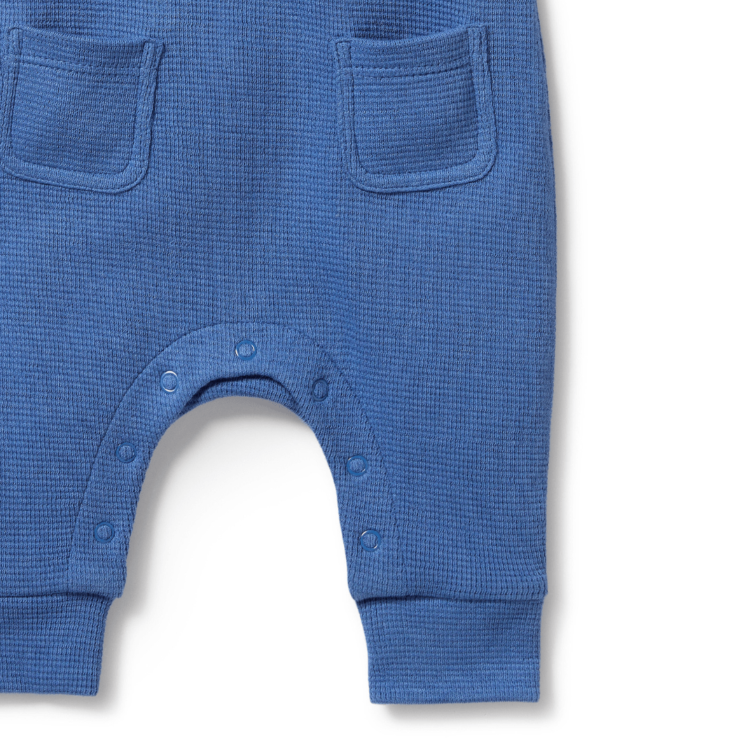 The Wilson & Frenchy Organic Waffle Overalls in Brilliant Blue, available only in size 18-24 months, are made from GOTS-certified organic cotton and feature two front pockets with snap buttons along the inner leg seam.