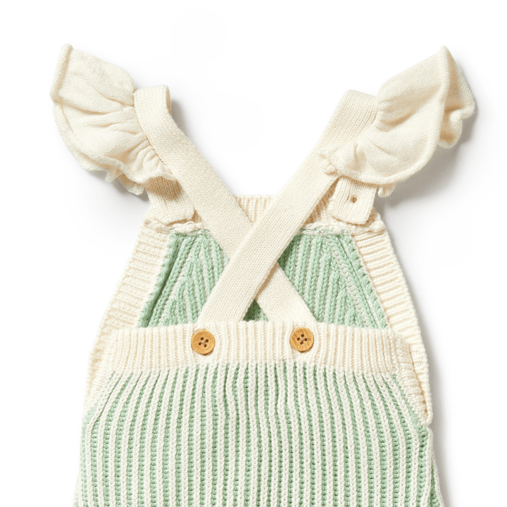 Discover Wilson & Frenchy's charming knitted ruffle overalls in Dijon, featuring adorable green and white stripes, ruffled shoulder straps crossed at the back, and button closures at the chest. These delightful overalls combine comfort with style for your little one.