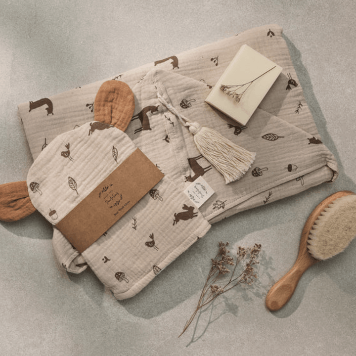 Flatlay-Of-Over-The-Dandelions-Organic-Muslin-Bear-Washcloth-Woodlands-With-Towel-And-Hairbrush-Naked-Baby-Eco-Boutique