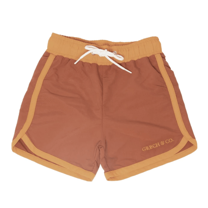 A boy's Grech & Co. UPF 40+ recycled swim trunks.