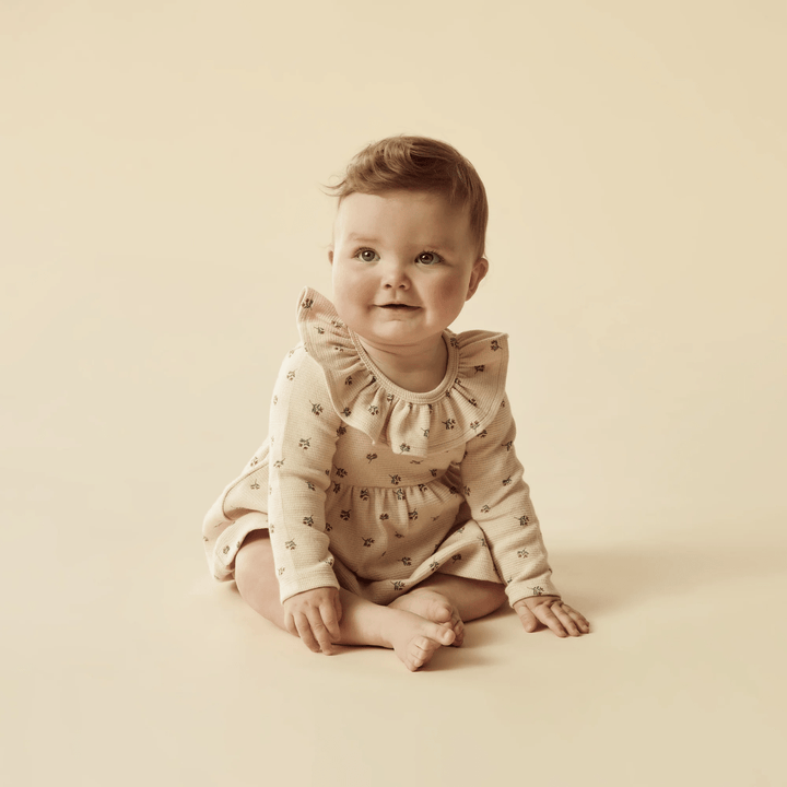 Happy-Baby-Sitting-Wearing-Wilson-And-Frenchy-Organic-Waffle-Long-Sleeved-Ruffle-Dress-Emily-Floral-Naked-Baby-Eco-Boutique