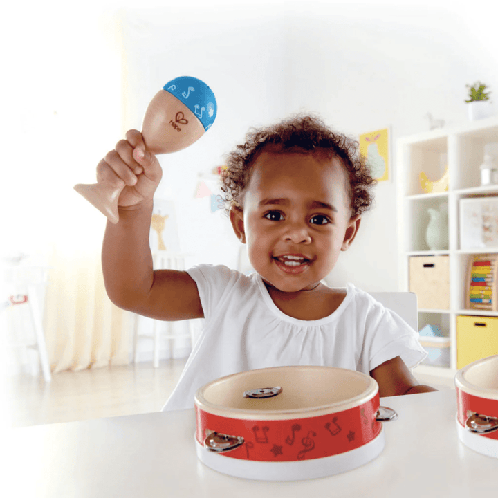 Happy-Girl-Playing-With-Maracca-In-Hape-Junior-Percussion-Set-Naked-Baby-Eco-Boutique