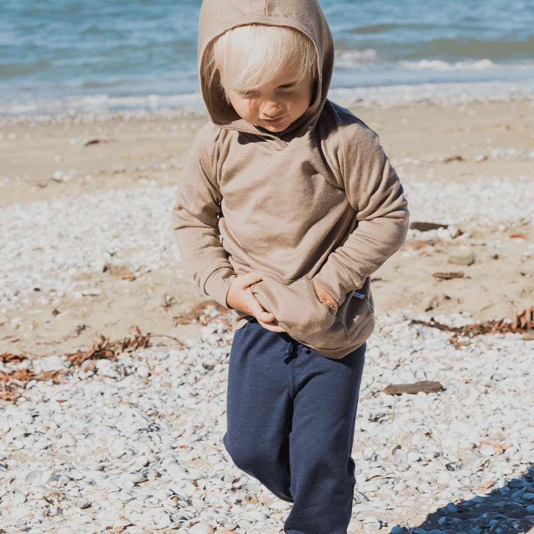 Little-Boy-on-Beach-Wearing-Babu-Cuffed-Merino-Pants-Denim-Naked-Baby-Eco-Boutique