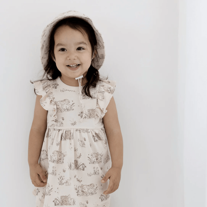 Little-Girl-Wearing-Matching-Sunhat-With-Aster-And-Oak-Organic-Cotton-Meadow-Ruffle-Dress-Naked-Baby-Eco-Boutique