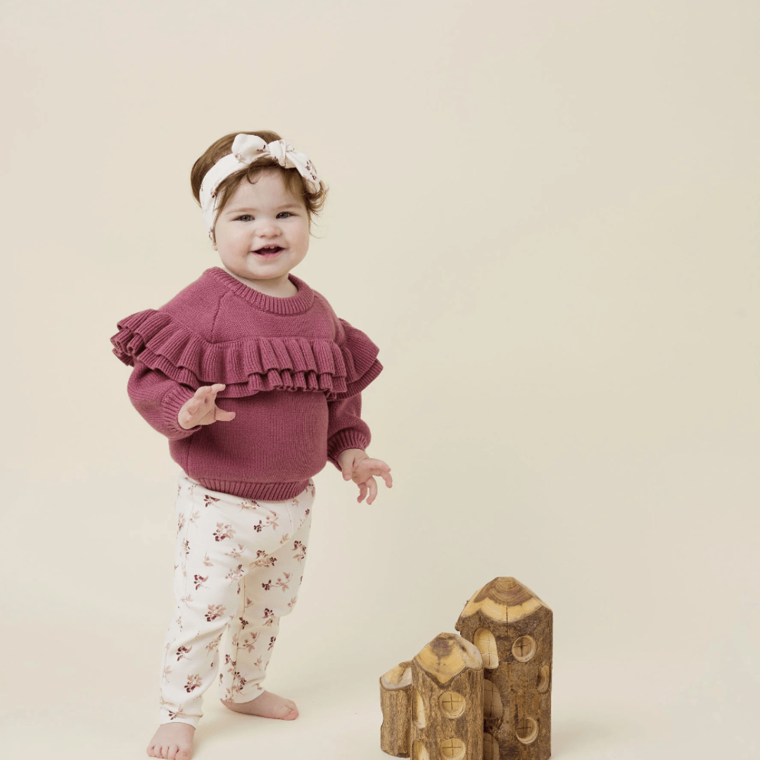 Little-Girl-in-Ruffle-Jumper-Standing-Wearing-Aster-and-Oak-Organic-Cotton-Leggings-Berry-Naked-Baby-Eco-Boutique