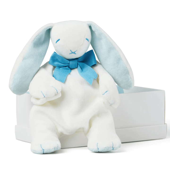 The Maud N Lil Organic Bunny Comforter - Gift Boxed, featuring a white plush bunny with blue inner ears and a blue bow, sitting on the edge of a white box, is an adorable organic cotton toy perfect as a baby gift.