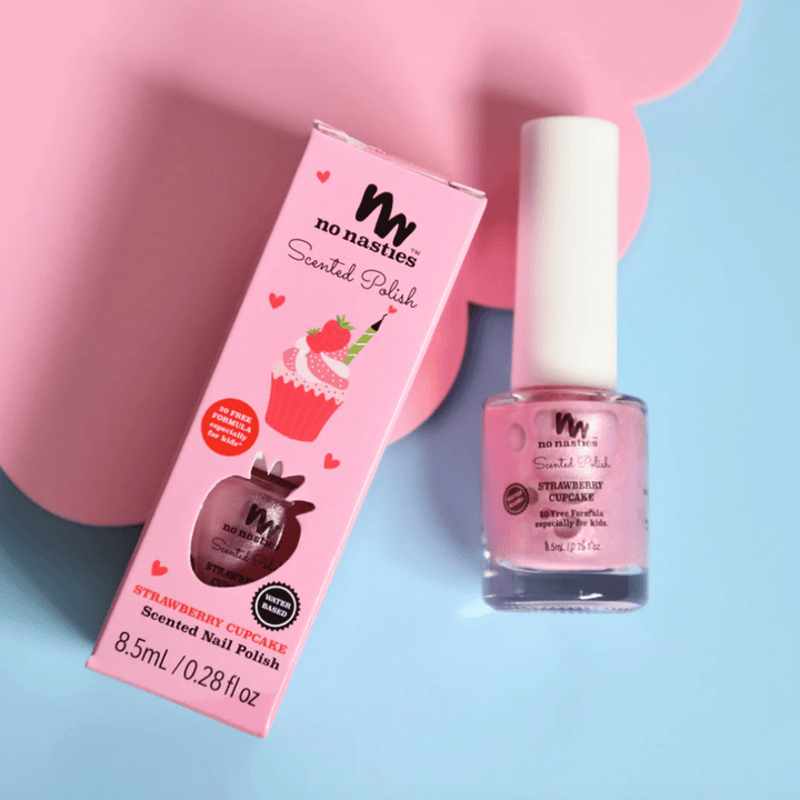 A bottle of No Nasties 20 FREE Kids Scented Nail Polish in strawberry cupcake scent is placed next to its pink packaging box that displays a cupcake image.