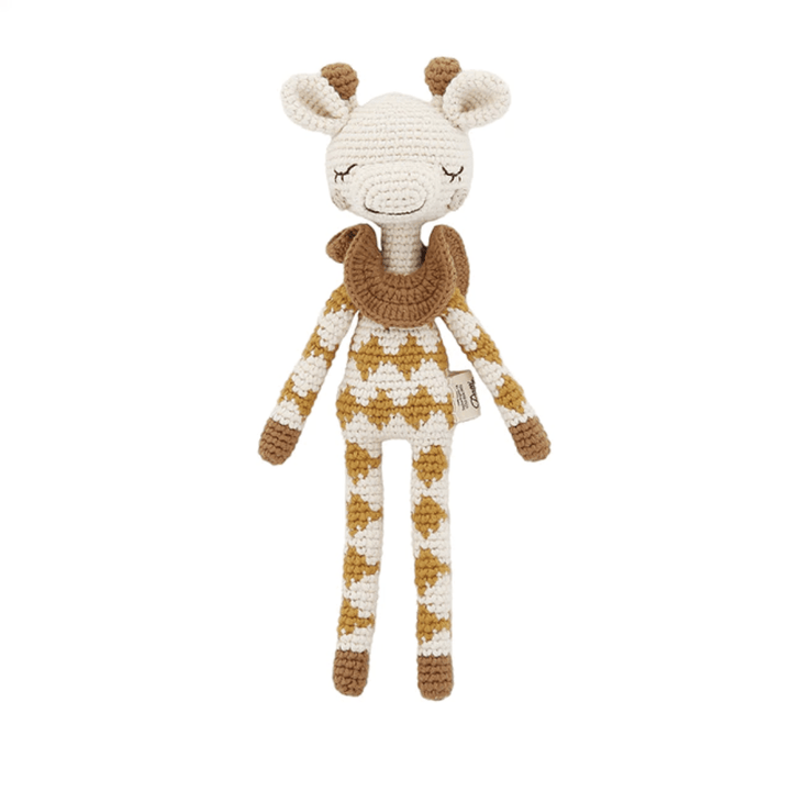 The Patti Oslo Organic Cotton Goldie Giraffe - LUCKY LAST is a lovingly crocheted toy with its eyes peacefully closed. This eco-friendly giraffe features an endearing brown scarf along with a stylishly patterned brown and white outfit, making it an ideal addition to any child's collection.