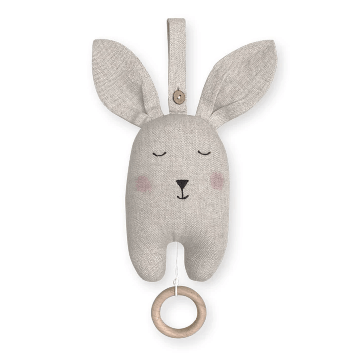 The Saga Copenhagen Organic Cotton Bunny Music Mobile by Saga Copenhagen is an ideal sustainable nursery accessory, featuring a bunny shape with closed eyes, pink cheeks, and a wooden ring pull at the bottom. It has long ears and a loop for hanging at the top, all crafted from GOTS certified organic cotton.