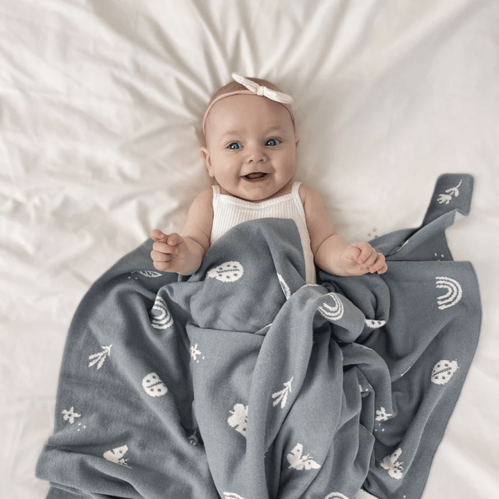 Styled-Image-Of-Little-Baby-With-Over-the-Dandelions-Organic-Cotton-Print-Blanket-Echanted-Garden-Sky-Naked-Baby-Eco-Boutique
