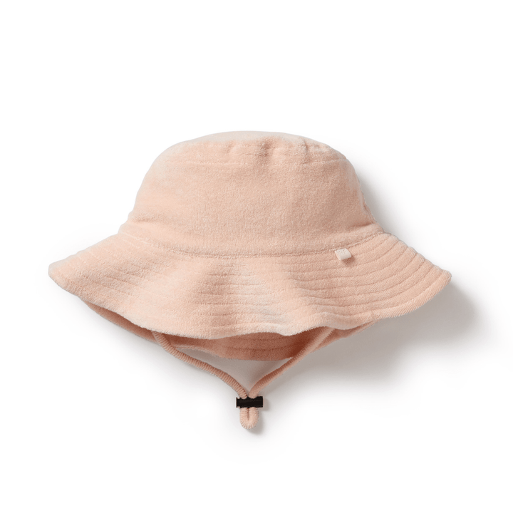 Introducing the Wilson & Frenchy Organic Terry Kids Sunhat in Sundial—the ideal sun protection for children on sunny days. This beige floppy bucket hat is made from organic cotton, featuring a wide brim and a chin strap, crafted from soft, textured fabric. It's perfect for outdoor adventures. Get yours now while supplies last!