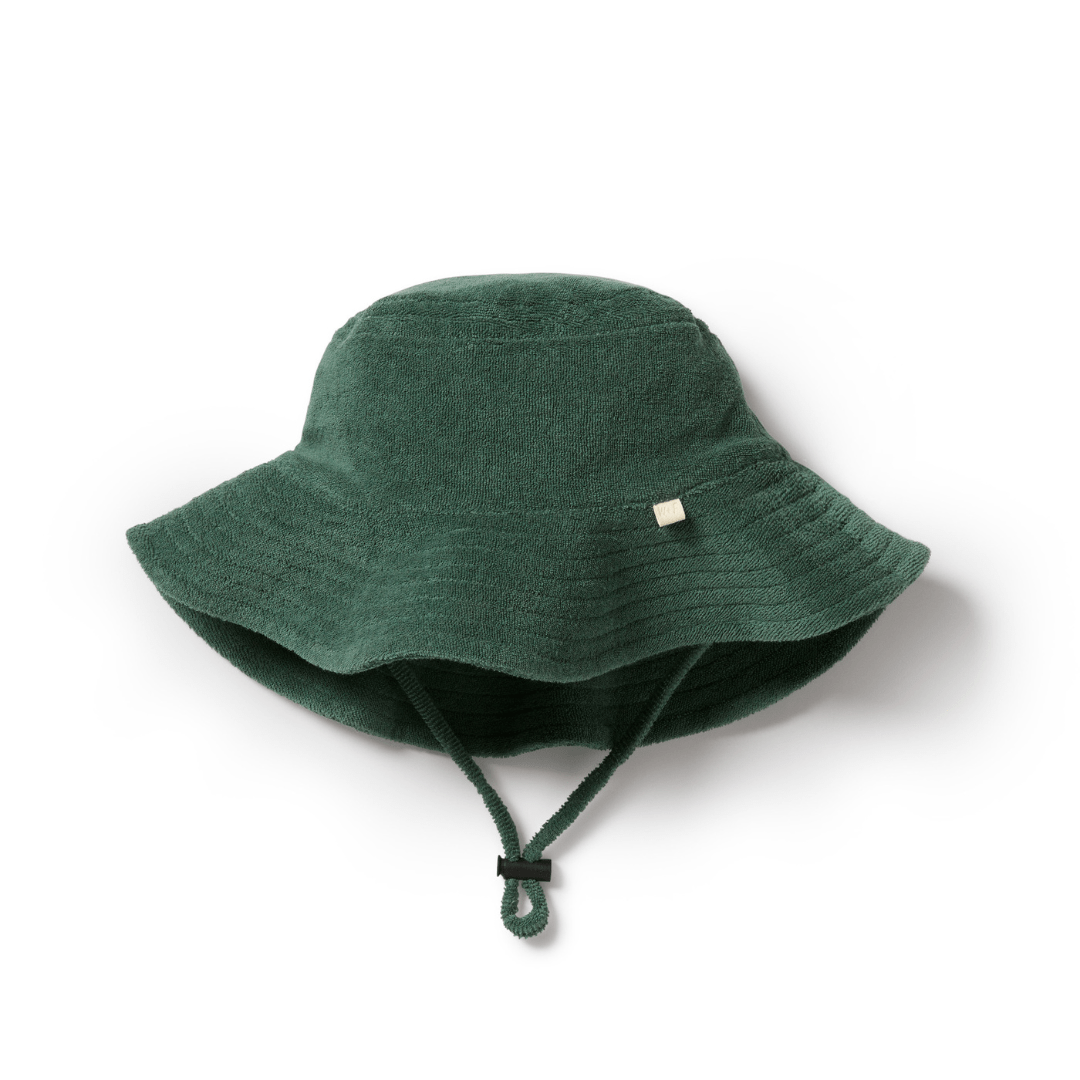 The Wilson & Frenchy Organic Terry Kids Sunhat - LUCKY LASTS - SUNDIAL ONLY is a sunhat made from organic cotton, showcasing a green bucket design with a chin strap and an additional small fabric tag to enhance both style and sun protection for children.