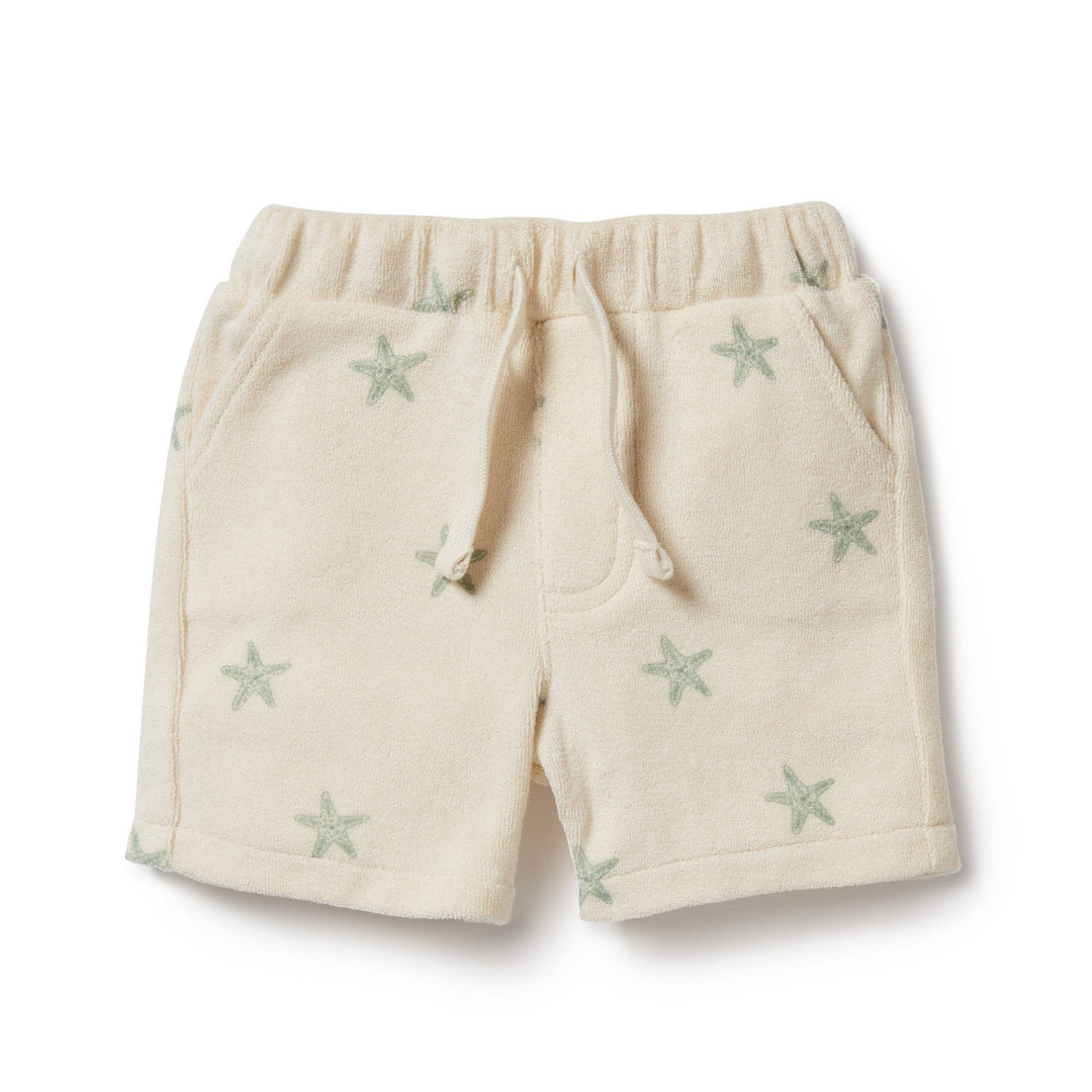 Introducing the Wilson & Frenchy Organic Terry Shorts, exclusively available in size 0-3 months and part of our LUCKY LASTS collection. These cream-colored toddler shorts feature a charming drawstring waistband and delightful starfish patterns. Made from GOTS-certified organic cotton, they come with convenient pockets and boast a soft fabric, making them the ideal summer essential for your little one.