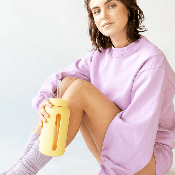 Woman-Sitting-Holding-Bink-Drink-Bottle-With-Glass-Straw-Naked-Baby-Eco-Boutique