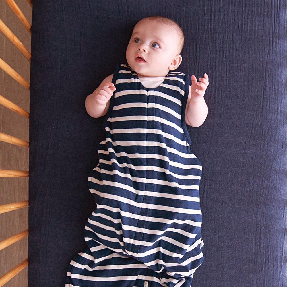 Baby-Lying-in-Cot-Wearing-Woolbabe-3-Seasons-Organic-Cotton-Merino-Sleeping-Bag-Midnight-Naked-Baby