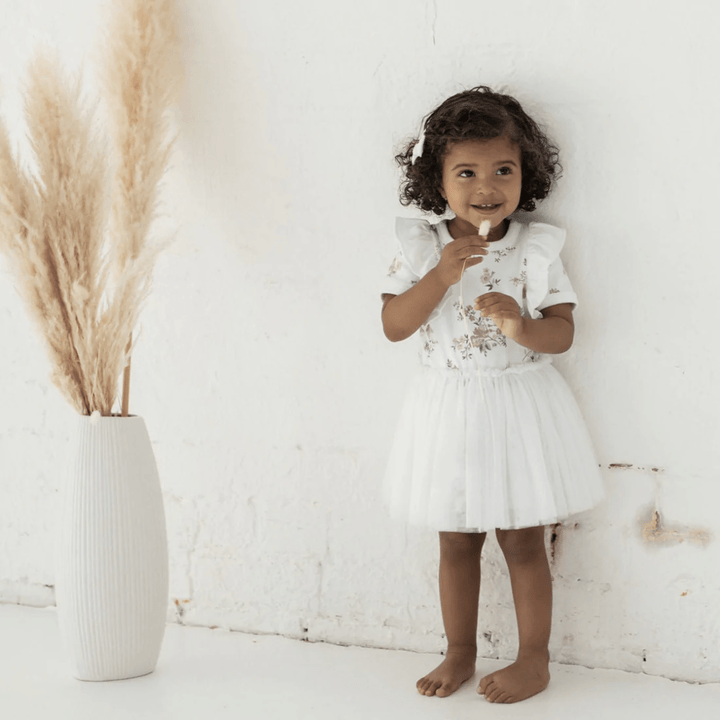 Happy-Girl-Wearing-Aster-And-Oak-Organic-Cotton-Primrose-Tutu-Dress-Naked-Baby-Eco-Boutique