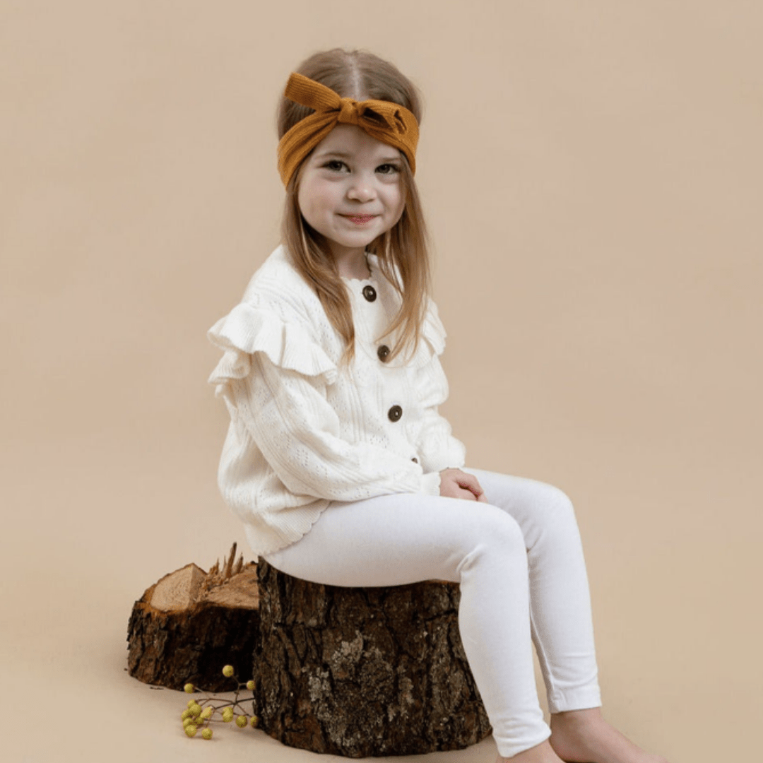 Little-Girl-Smiling-Wearing-Aster-And-Oak-Organic-Ruffle-Knit-Cardigan-Off-White-Naked-baby-Eco-Boutique