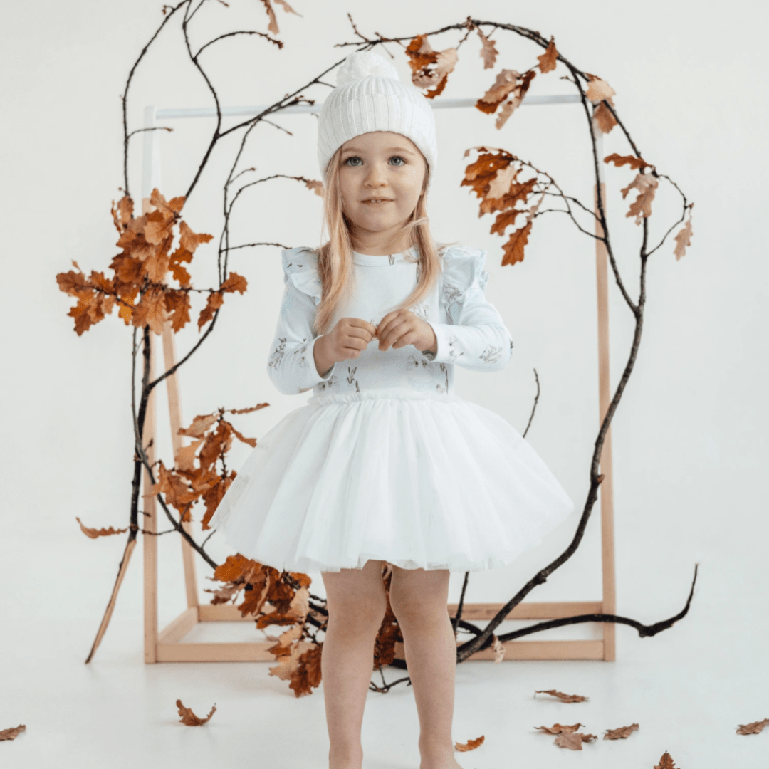 Little-Girl-Standing-in-Leaves-Wearing-Aster-and-Oak-Organic-Tutu-Dress-Swan-Naked-Baby-Eco-Boutique