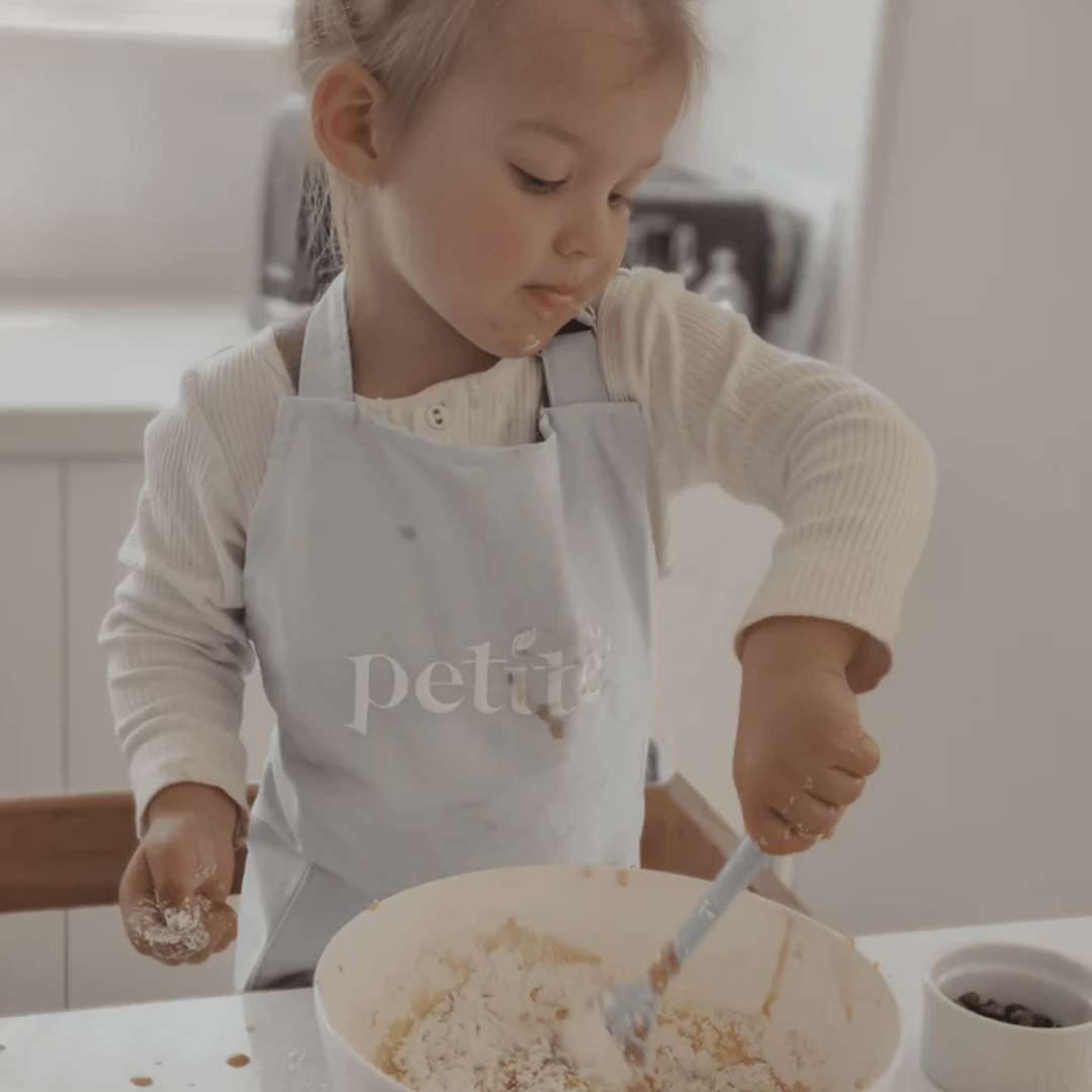 Little-Girl-Wearing-Apron-Petite-Eats-Kids-Kitchenware-Set-Sky-Naked-Baby-Eco-Boutique