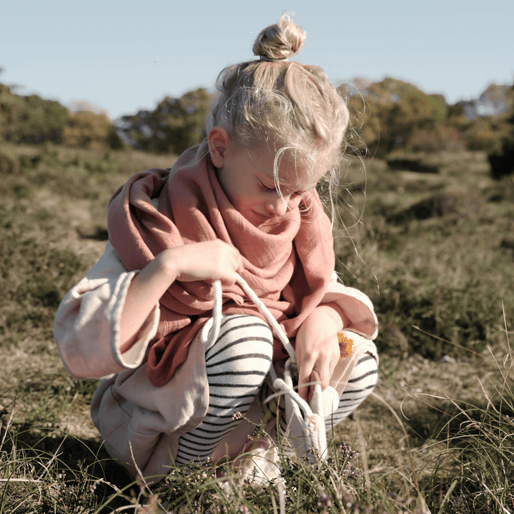 Little-Girl-Wearing-Fabelab-Organic-Cotton-Swaddle-Blanket-Clay-as-Scarf-Naked-Baby-Eco-Boutique