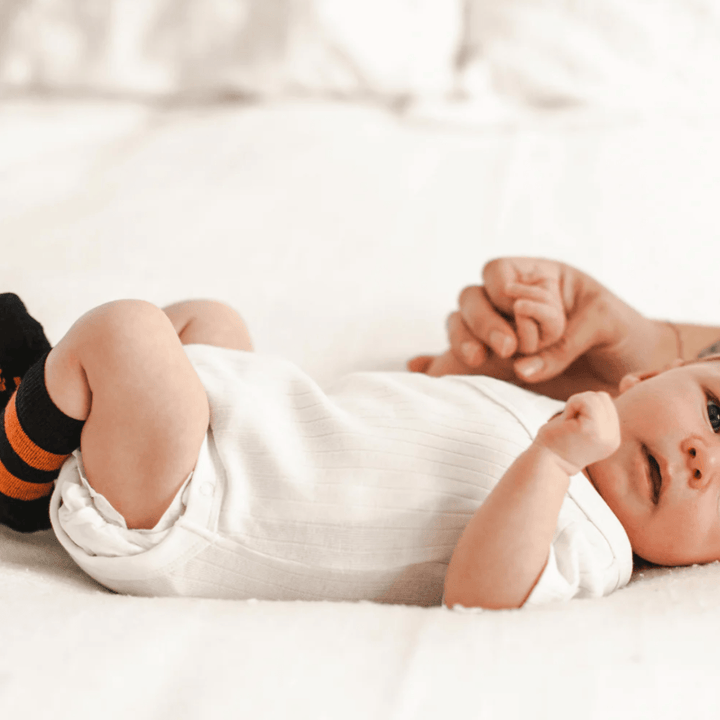 Newborn-Baby-Lying-Down-Wearing-Lamington-Merino-Wool-Crew-Baby-Socks-Kaa-Naked-Baby-Eco-Boutique