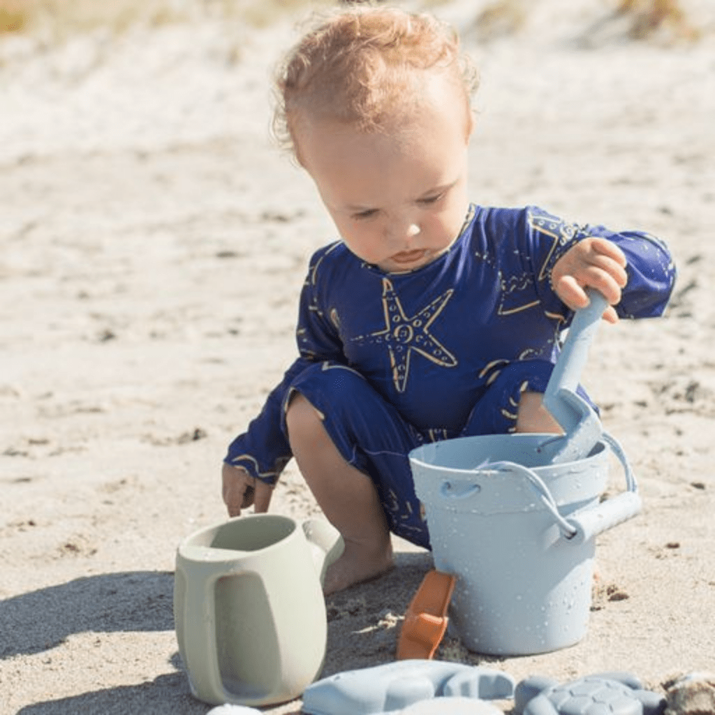 Saylor-Mae-Silicone-Beach-Toy-Set-Little-Boy-Playing-With-Boathouse-Blue-Set-Naked-Baby-Eco-Boutique