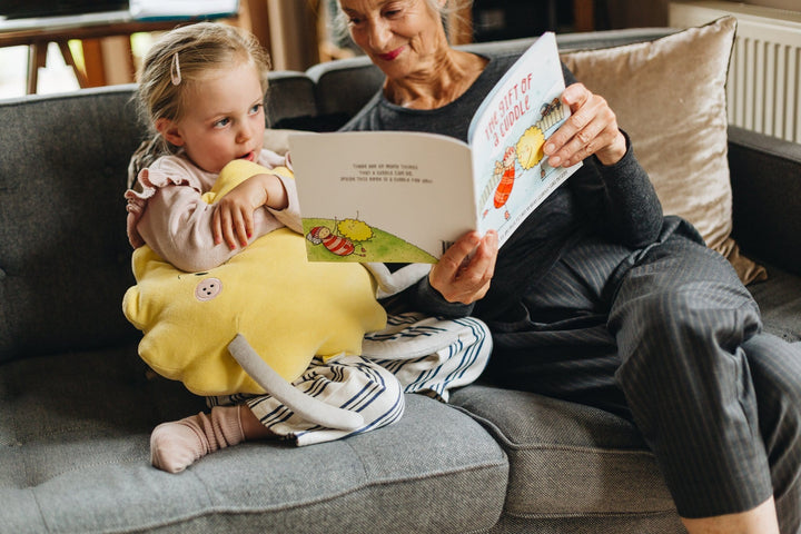 Little-Girl-Reading-Book-with-The-Kiss-Co-Organic-Cotton-Big-Cuddle-Stuffed-Toy-Naked-Baby-Eco-Boutique